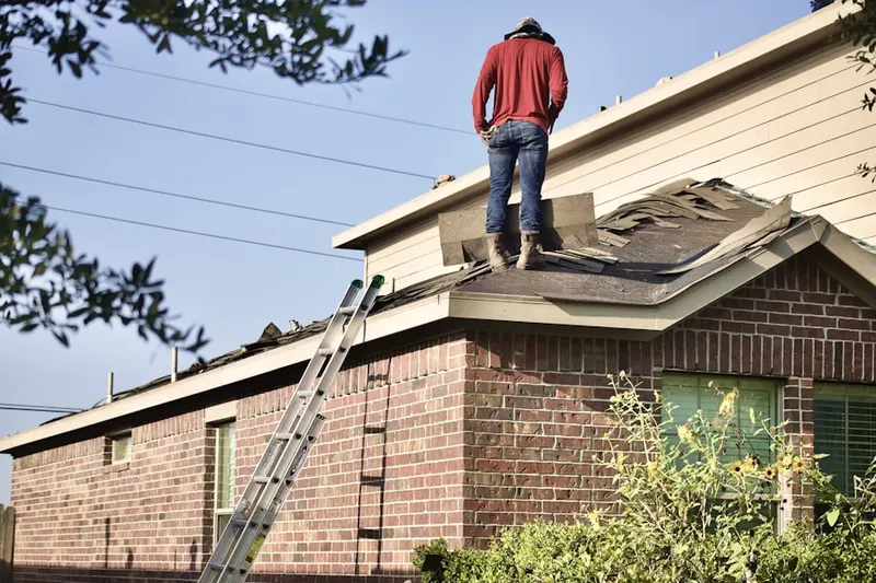 Professional roofer working on a residential roof in Benedict
